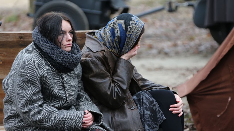 Two tired women sitting outside in Ukraine.