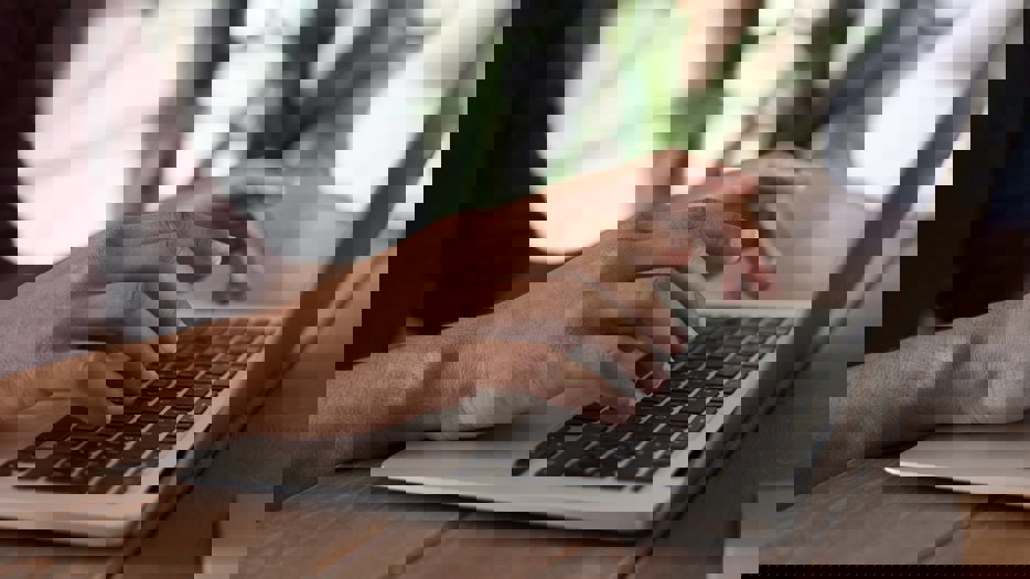 Fingers typing on a laptop